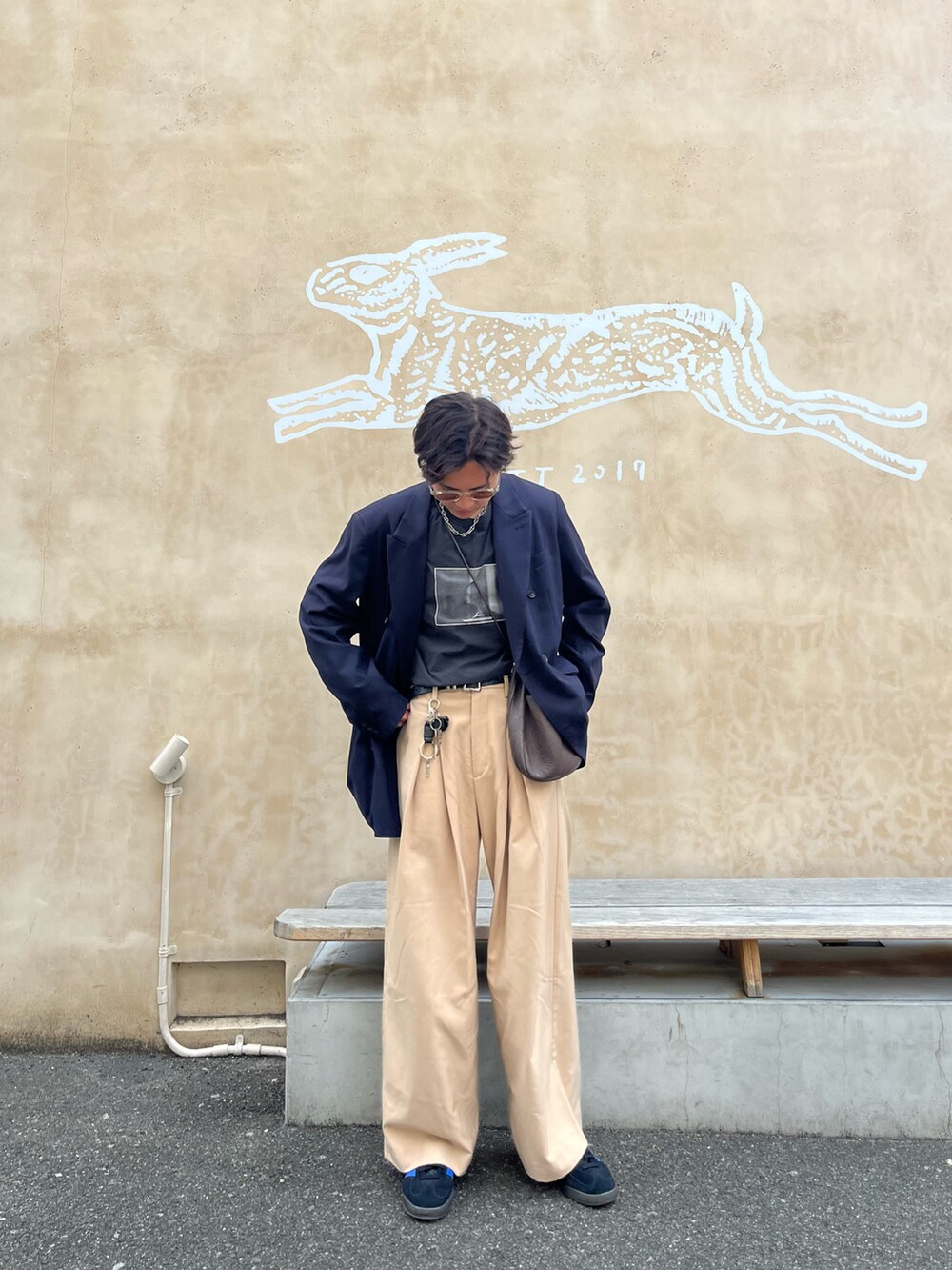 ブラック系のTシャツ/カットソー、ブルー系のテーラードジャケット、ブルー系のスニーカーを着用したメンズの春コーディネートの3枚目の写真