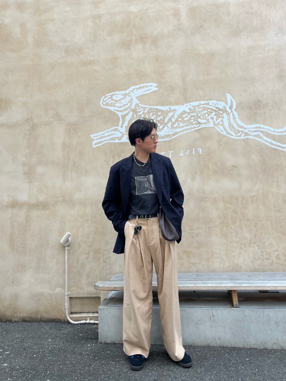 ブラック系のTシャツ/カットソー、ブルー系のテーラードジャケット、ブルー系のスニーカーを着用したメンズの春コーディネートの4枚目の写真