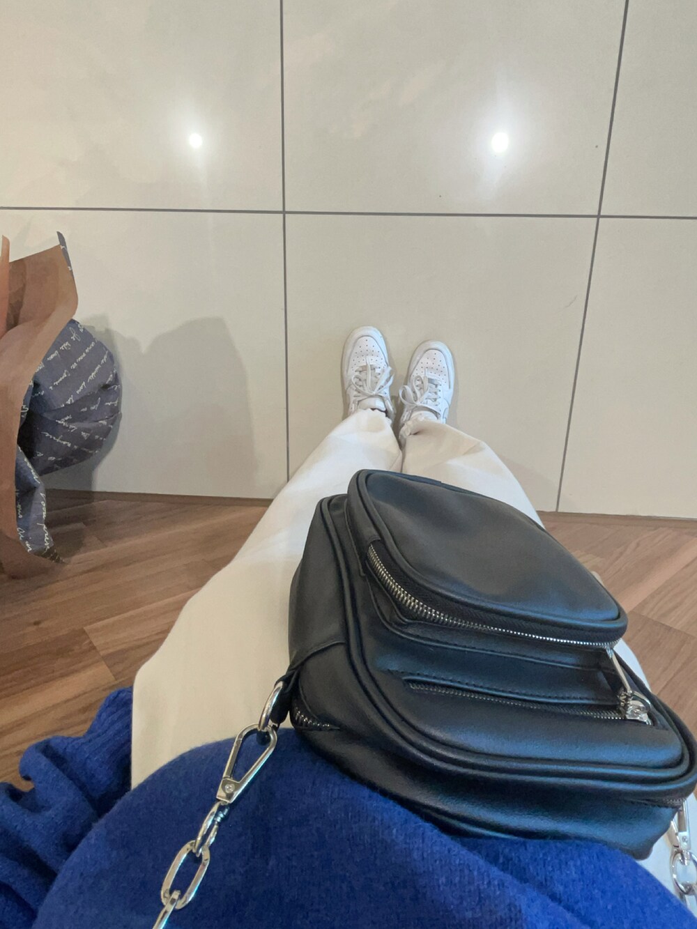 ブルー系のニット/セーター、ホワイト系のスウェットパンツを着用したレディースの秋コーディネートの2枚目の写真