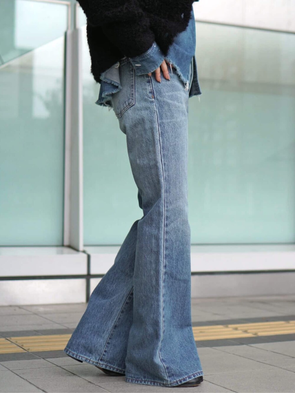 ブルー系のデニムパンツ、ブラック系のその他アウターを着用したレディースの秋コーディネートの4枚目の写真