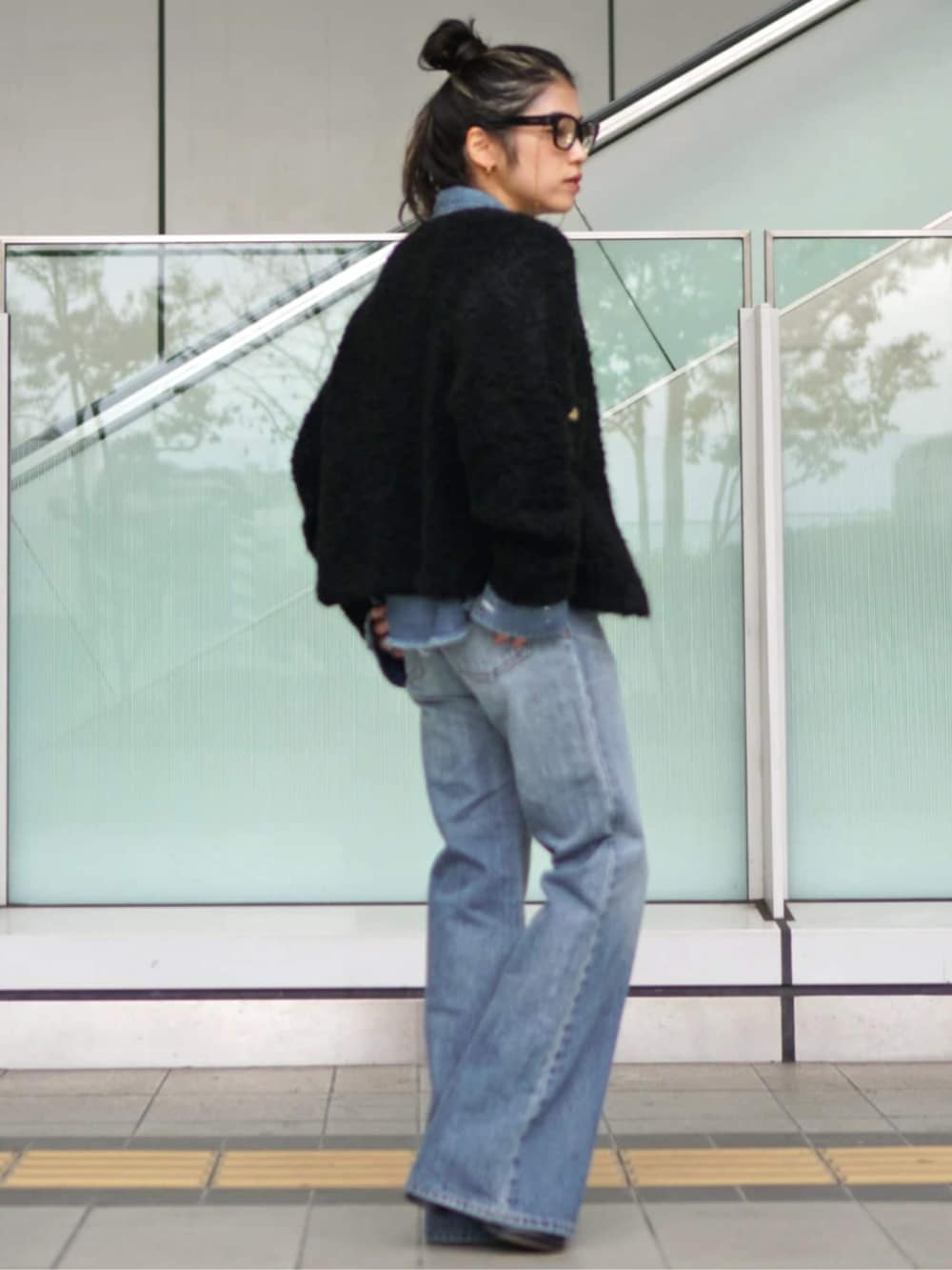 ブルー系のデニムパンツ、ブラック系のその他アウターを着用したレディースの秋コーディネートの2枚目の写真