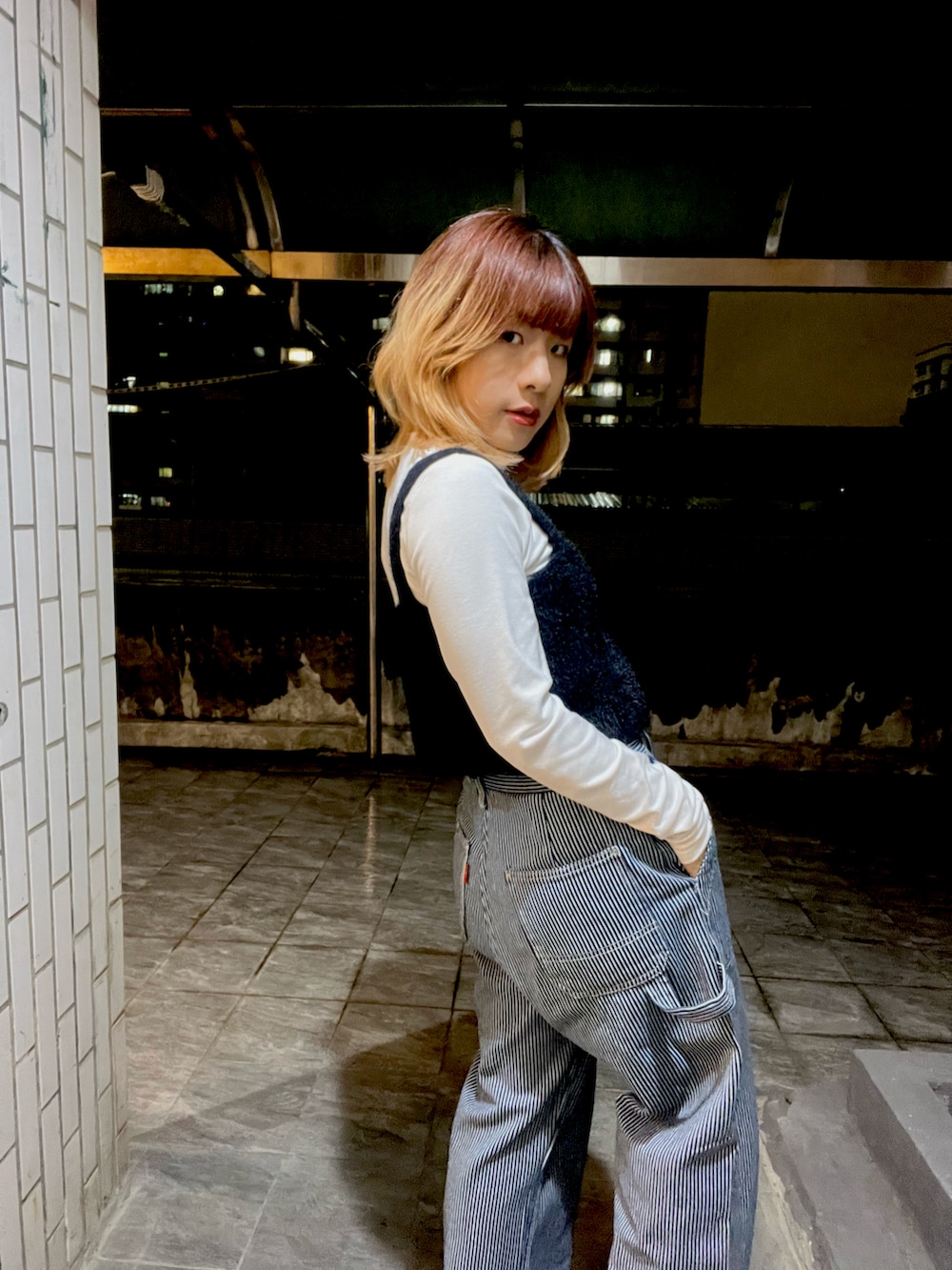 その他のデニムパンツ、ブラック系のベストを着用したレディースの春コーディネートの3枚目の写真