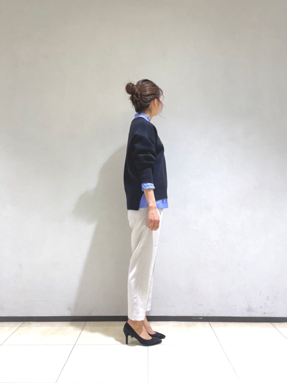 ブラック系のニット/セーター、ブルー系のシャツ/ブラウス、グレー系のその他パンツを着用したレディースの冬コーディネートの2枚目の写真