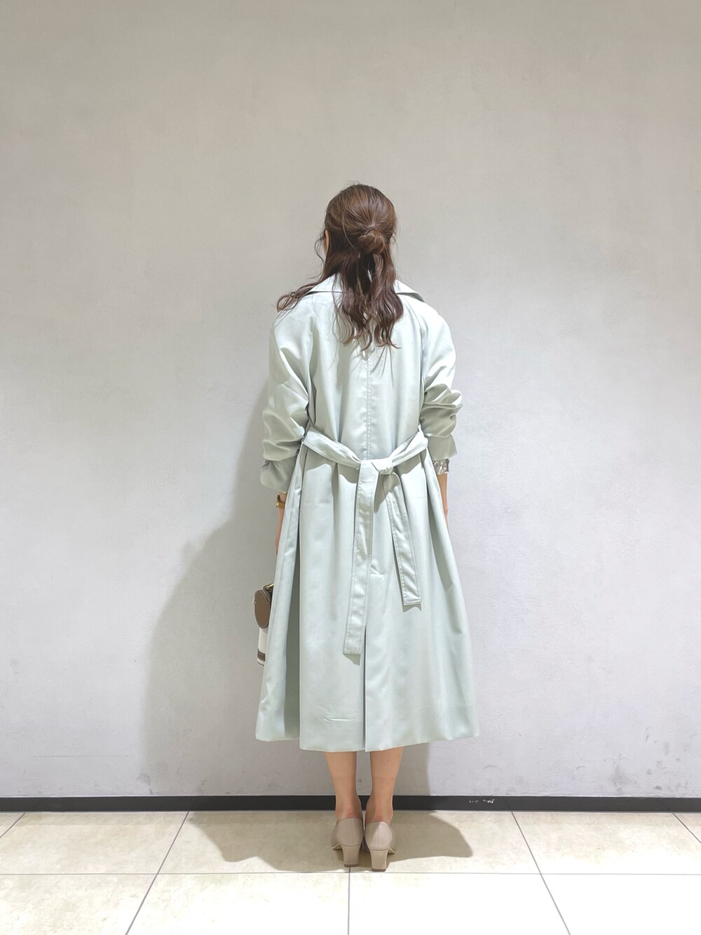 ホワイト系のシャツ/ブラウス、グリーン系のトレンチコート、ホワイト系のスカートを着用したレディースの春コーディネートの4枚目の写真