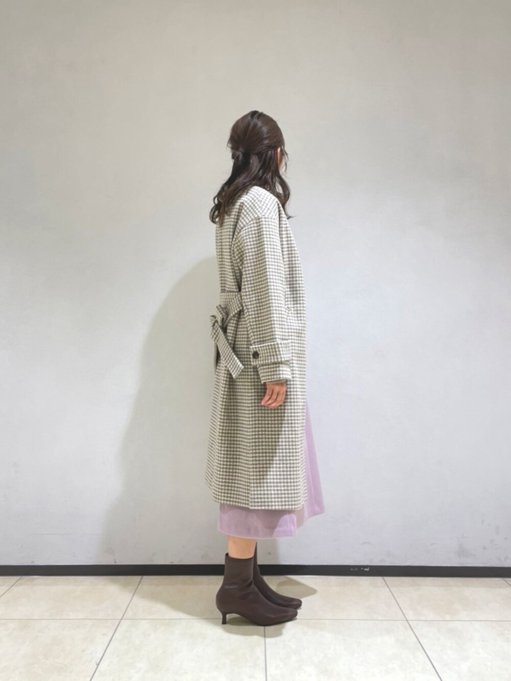 ベージュ系のニット/セーター、ピンク系のスカート、ベージュ系のショルダーバッグを着用したレディースの冬コーディネートの3枚目の写真