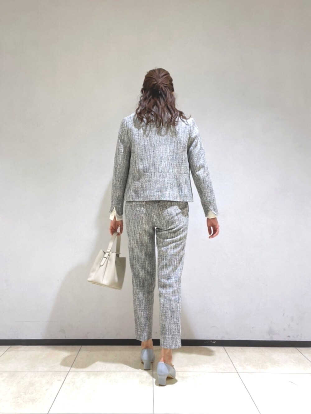 ブラック系のノーカラージャケット、ホワイト系のシャツ/ブラウス、ブラック系のその他パンツを着用したレディースの冬コーディネートの3枚目の写真