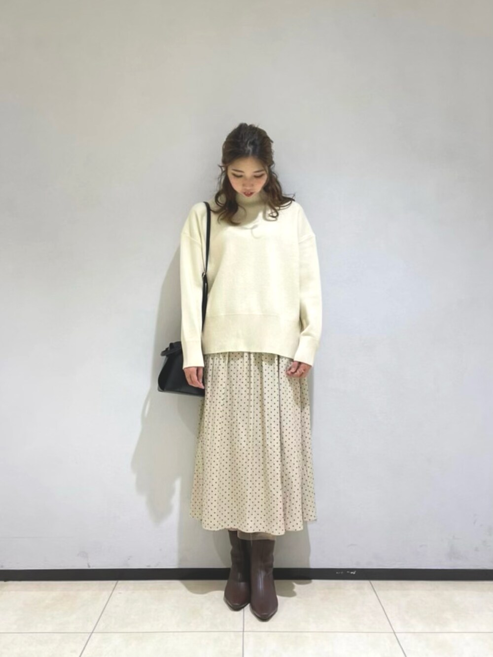 グリーン系のその他アウター、ホワイト系のニット/セーター、ブラック系のショルダーバッグを着用したレディースの冬コーディネートの2枚目の写真