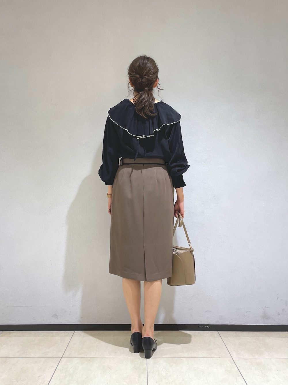 ブラック系のシャツ/ブラウス、イエロー系のショルダーバッグ、ブラウン系のスカートを着用したレディースの秋コーディネートの3枚目の写真