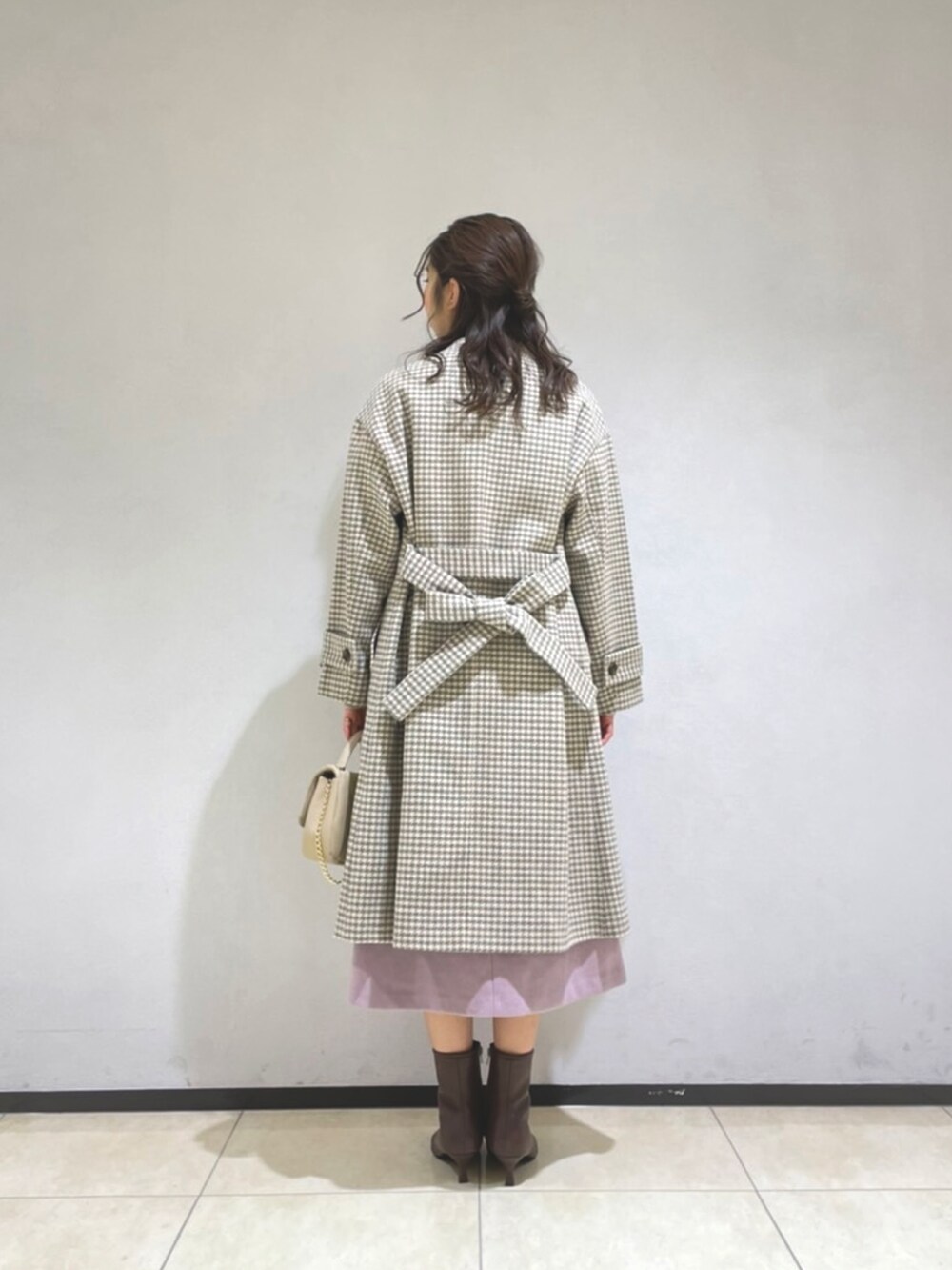 ベージュ系のニット/セーター、ピンク系のスカート、ベージュ系のショルダーバッグを着用したレディースの冬コーディネートの4枚目の写真