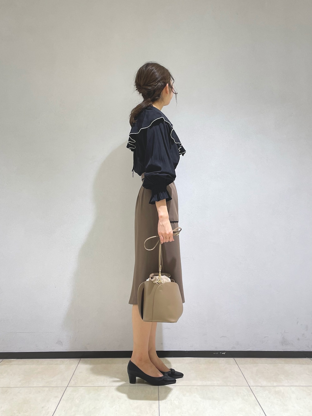 ブラック系のシャツ/ブラウス、イエロー系のショルダーバッグ、ブラウン系のスカートを着用したレディースの秋コーディネートの2枚目の写真