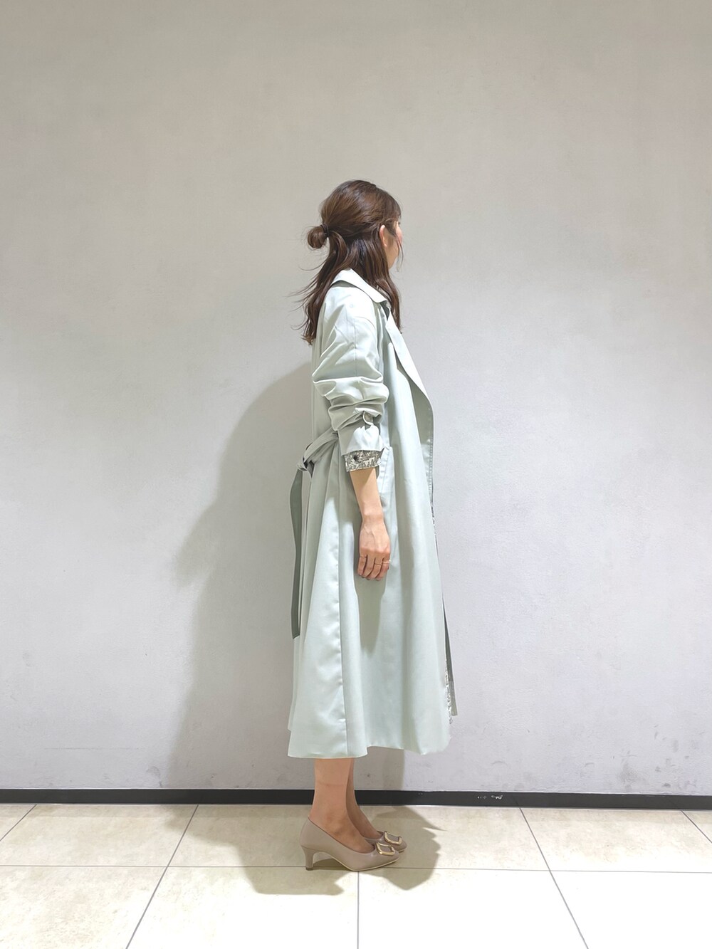 ホワイト系のシャツ/ブラウス、グリーン系のトレンチコート、ホワイト系のスカートを着用したレディースの春コーディネートの3枚目の写真