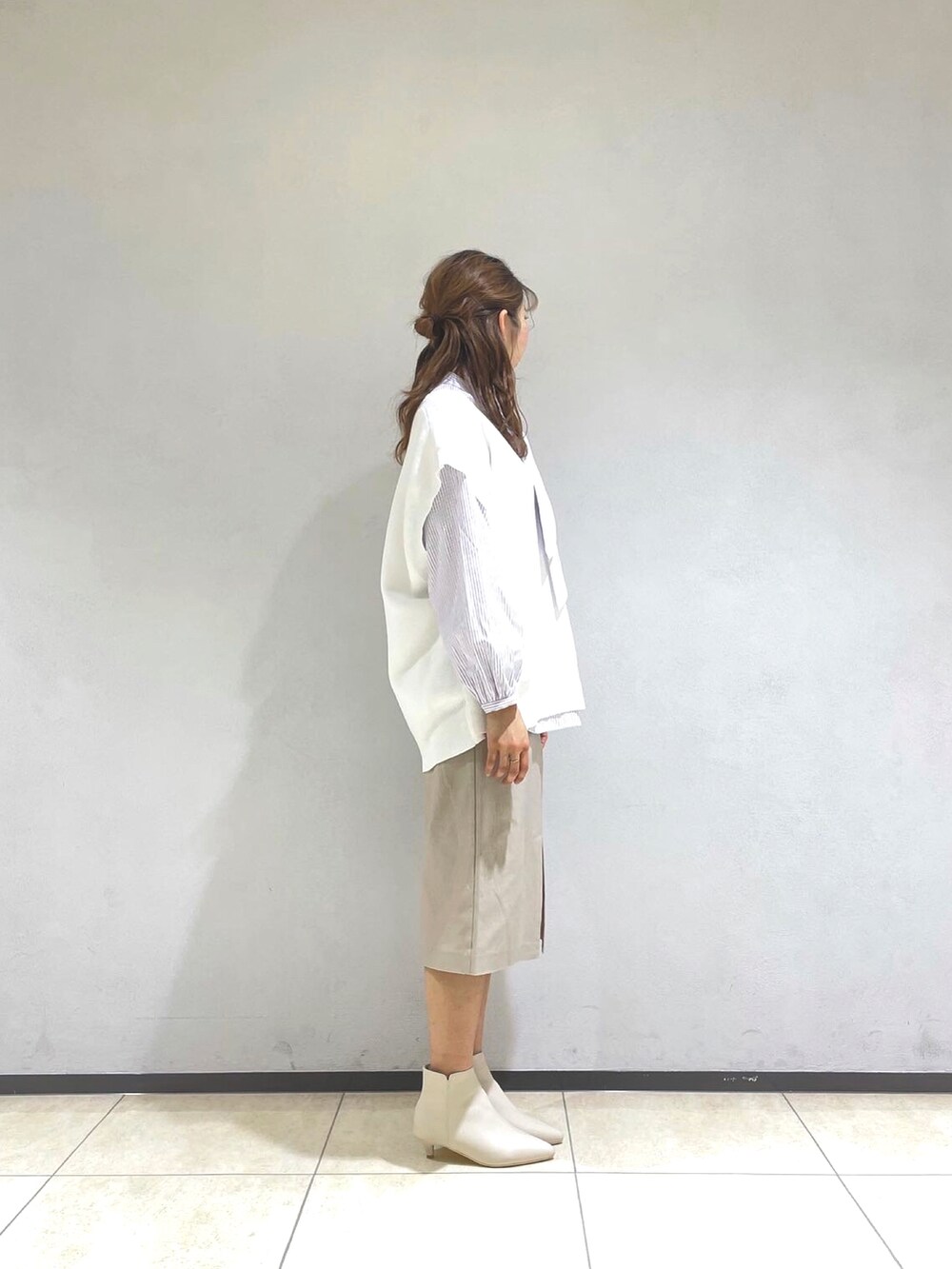 パープル系のシャツ/ブラウス、ホワイト系のベスト、ベージュ系のスカートを着用したレディースの冬コーディネートの2枚目の写真