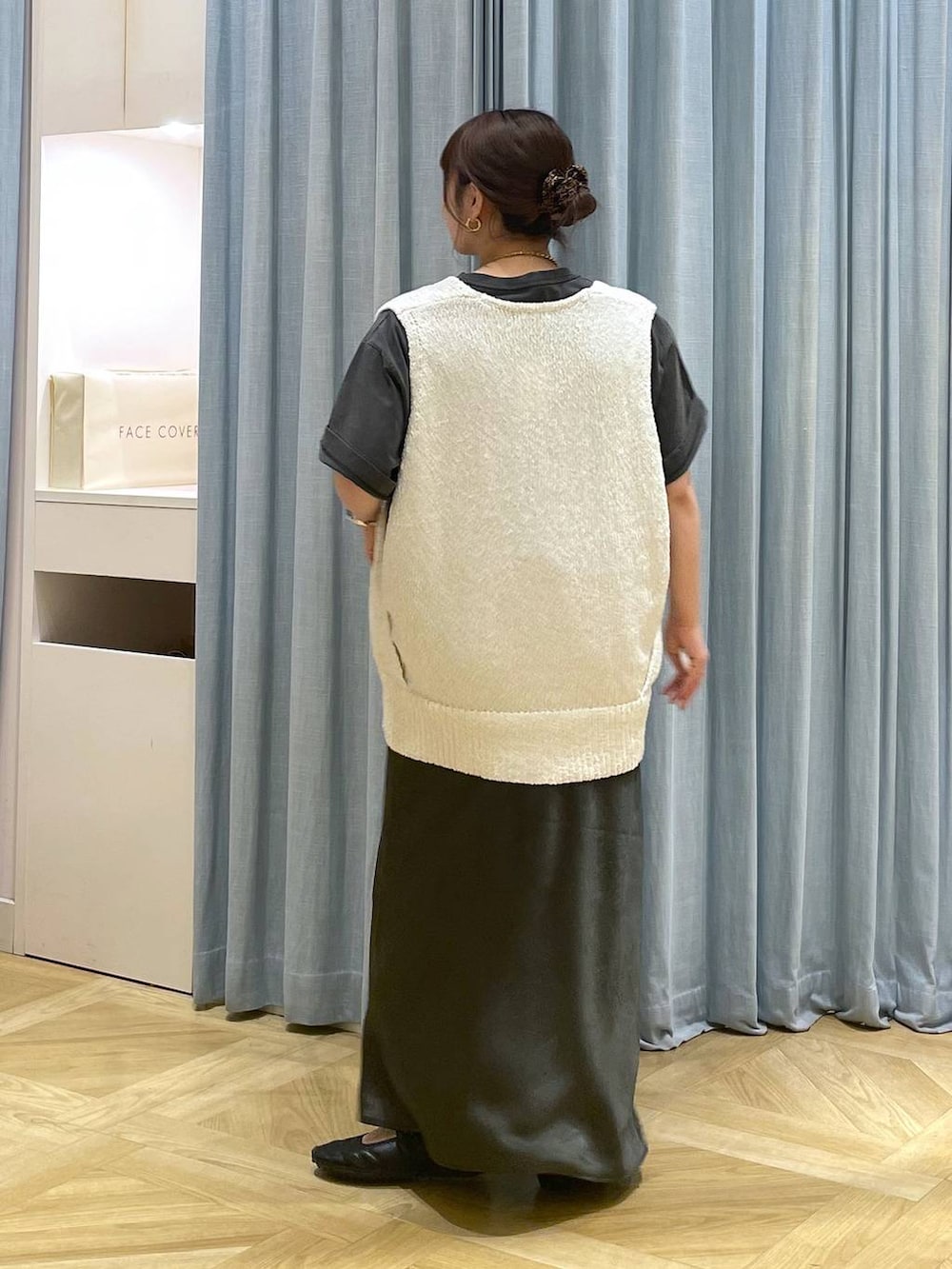 ブラック系のスニーカー、グレー系のスカート、ホワイト系のニット/セーターを着用したレディースの春コーディネートの2枚目の写真