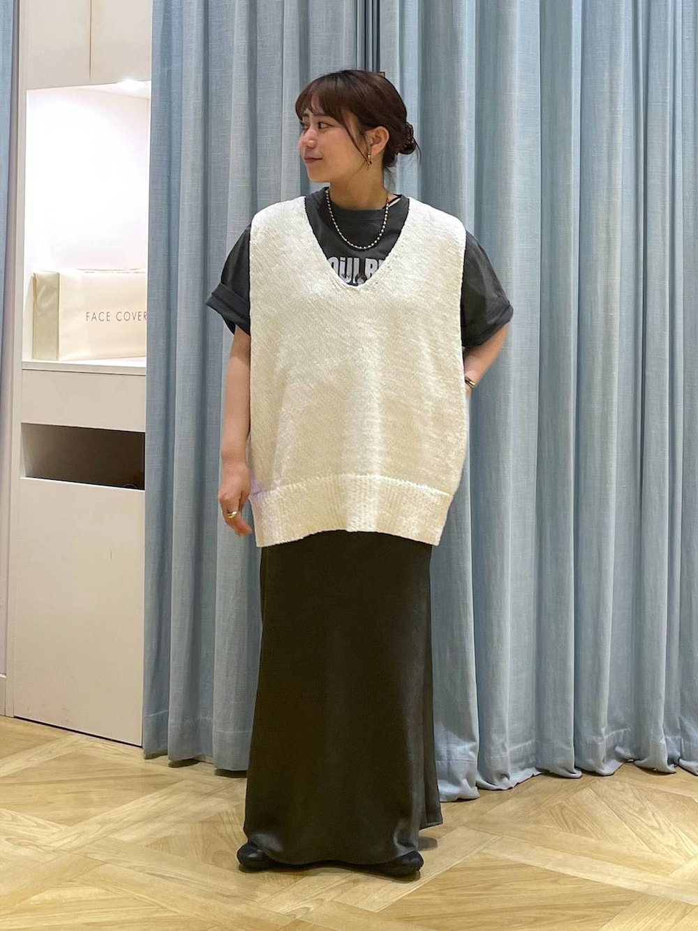 ブラック系のスニーカー、グレー系のスカート、ホワイト系のニット/セーターを着用したレディースの春コーディネートの3枚目の写真