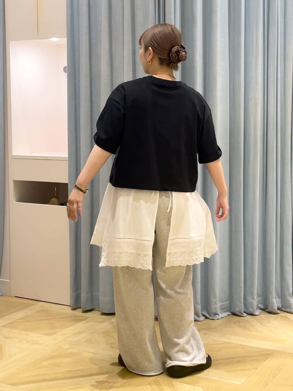 ブラック系のサンダル、ブラック系のTシャツ/カットソー、グレー系のスウェットパンツを着用したレディースの春コーディネートの3枚目の写真