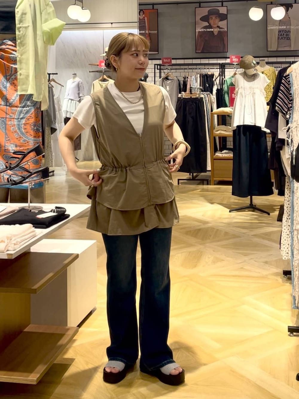 ホワイト系のTシャツ/カットソー、シルバー系のサンダル、ブルー系のデニムパンツを着用したレディースの夏コーディネートの2枚目の写真