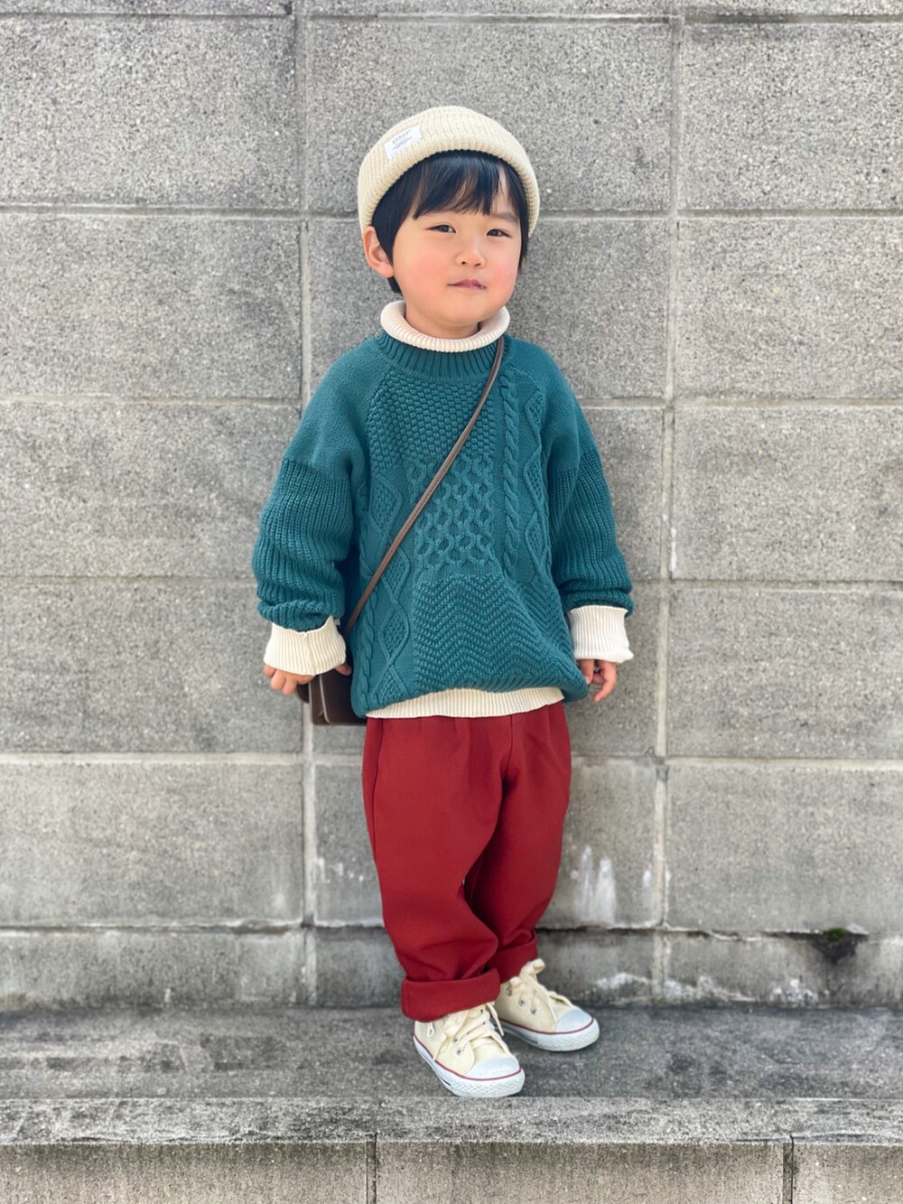 グリーン系のニット/セーター、ホワイト系のニット/セーター、レッド系のその他パンツを着用したキッズの冬コーディネートの2枚目の写真