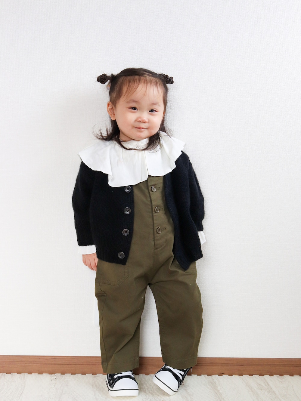 ブラック系のカーディガン/ボレロ、グリーン系のサロペット/オーバーオール、ホワイト系のシャツ/ブラウスを着用したキッズの秋コーディネートの3枚目の写真