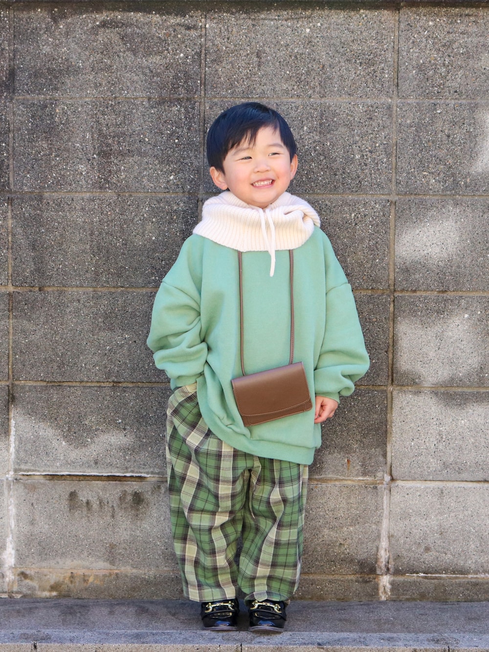 グリーン系のスウェット、グリーン系のその他パンツ、ブラック系のローファーを着用したキッズの冬コーディネートの2枚目の写真