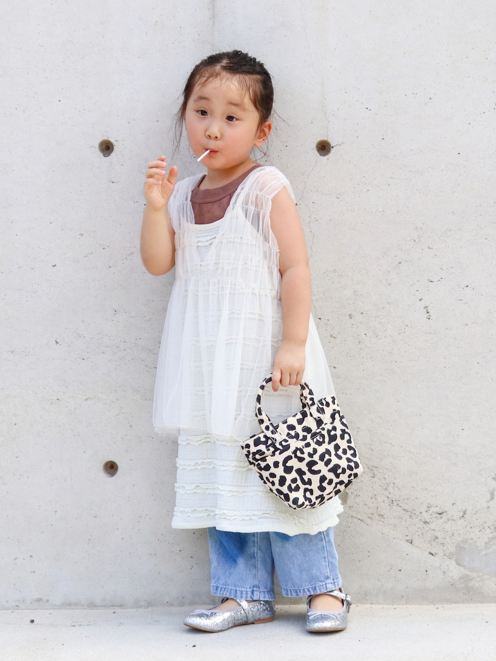 ホワイト系のチュニック、ブラウン系のタンクトップ、ホワイト系のワンピースを着用したキッズの夏コーディネートの2枚目の写真