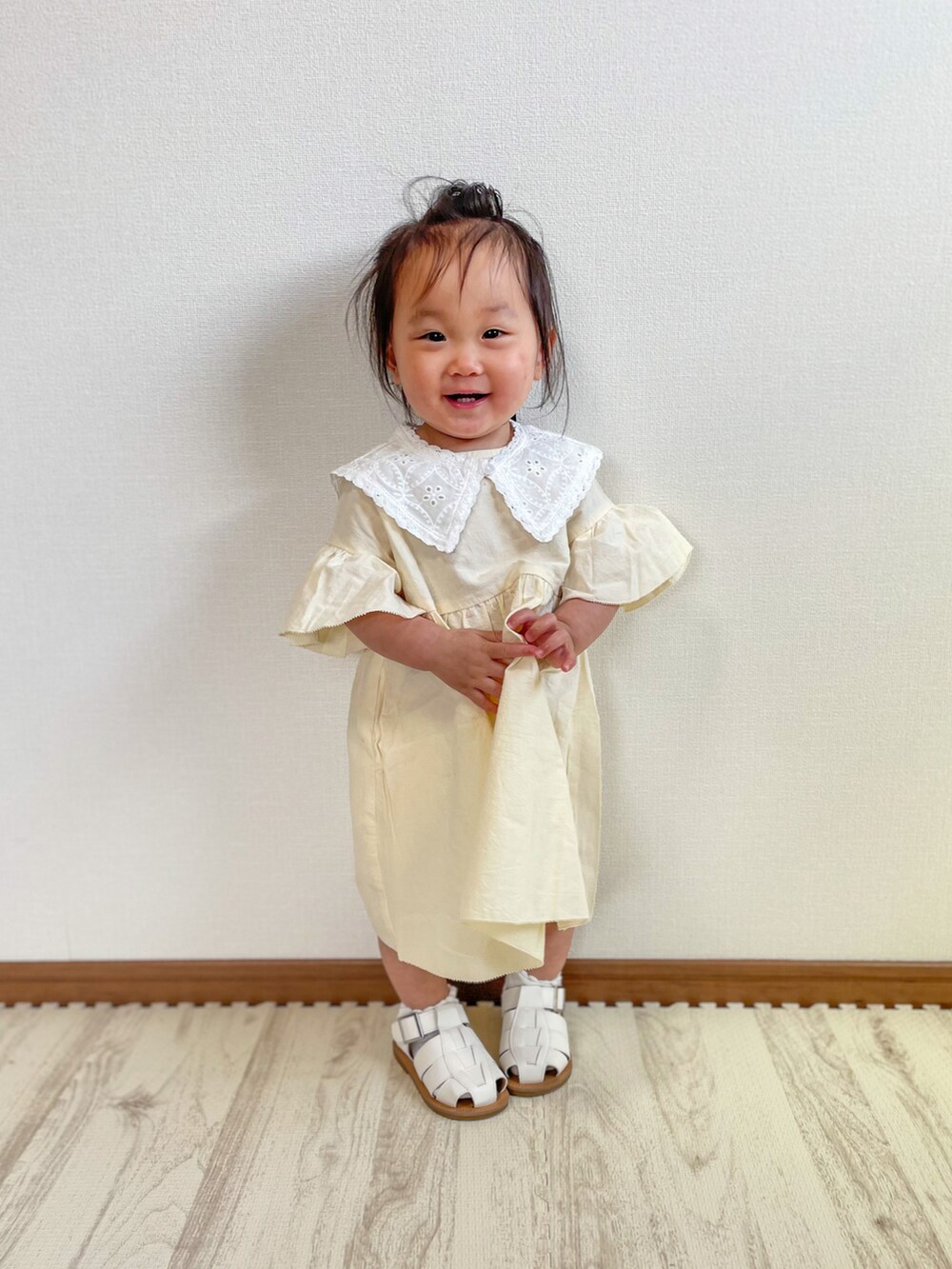 ホワイト系のワンピース、ホワイト系のサンダルを着用したキッズの春コーディネートの3枚目の写真