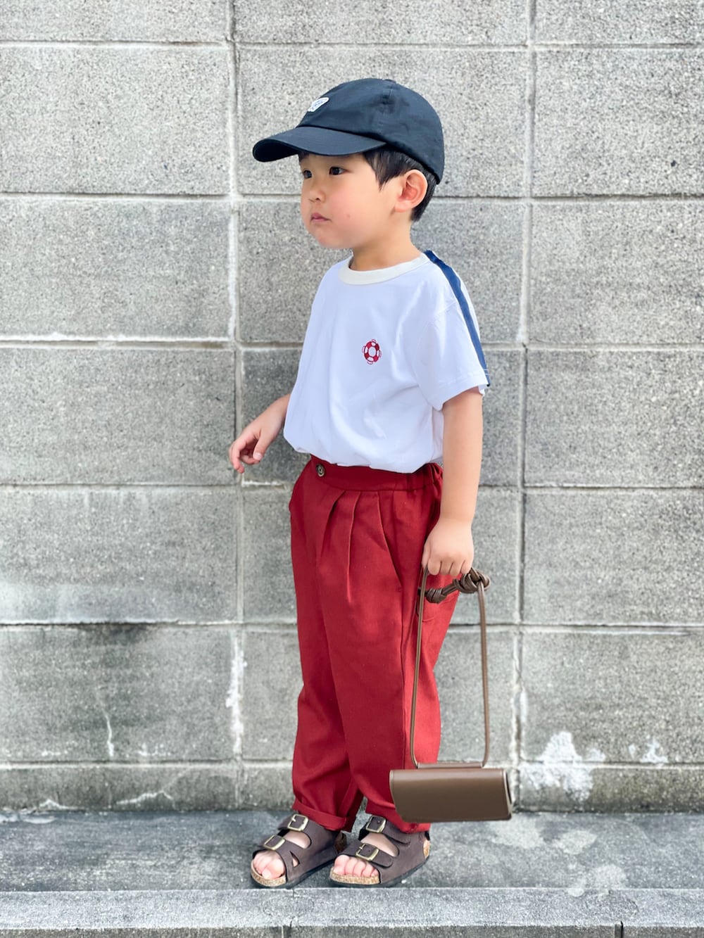 ホワイト系のTシャツ/カットソー、レッド系のその他パンツ、ブラウン系のサンダルを着用したキッズの夏コーディネートの2枚目の写真