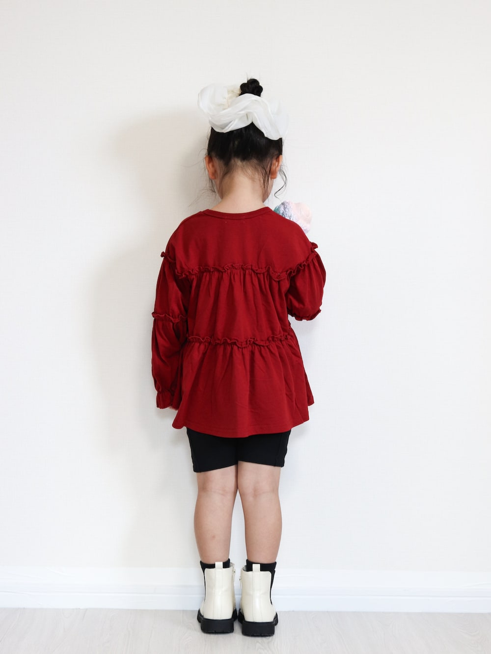 ブラック系のその他パンツ、ホワイト系のブーツ、レッド系のTシャツ/カットソーを着用したキッズの秋コーディネートの4枚目の写真