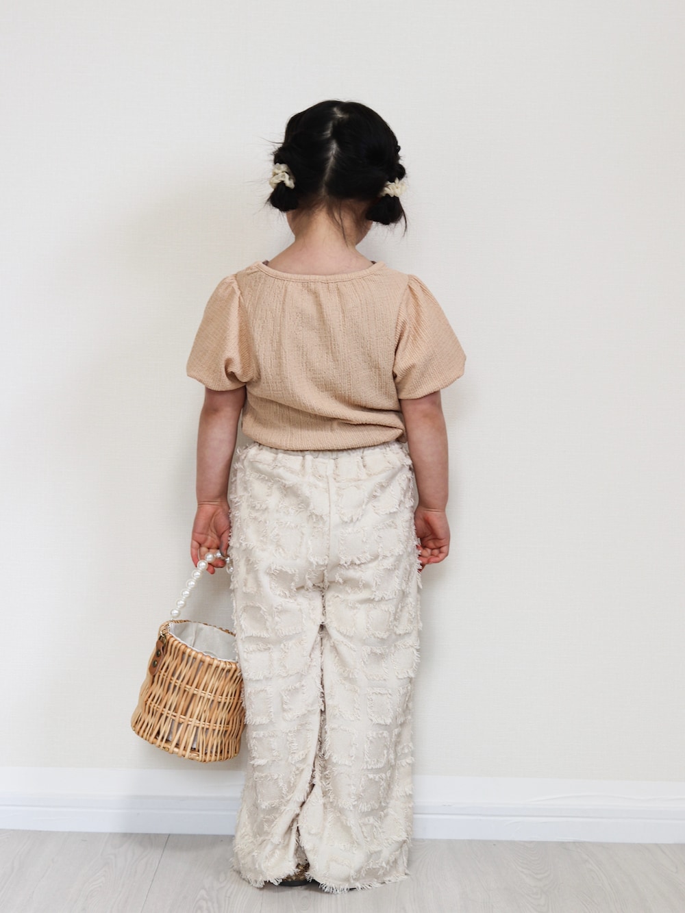 ピンク系のTシャツ/カットソー、ベージュ系のその他パンツ、ブラウン系のタンクトップを着用したキッズの春コーディネートの3枚目の写真