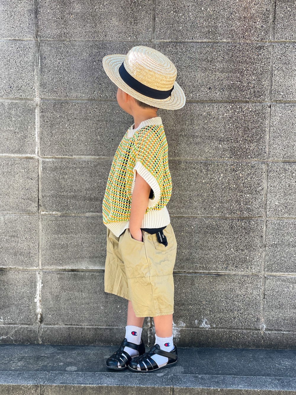 グリーン系のベスト、ブラック系のタンクトップ、ベージュ系のパンツを着用したキッズの夏コーディネートの3枚目の写真