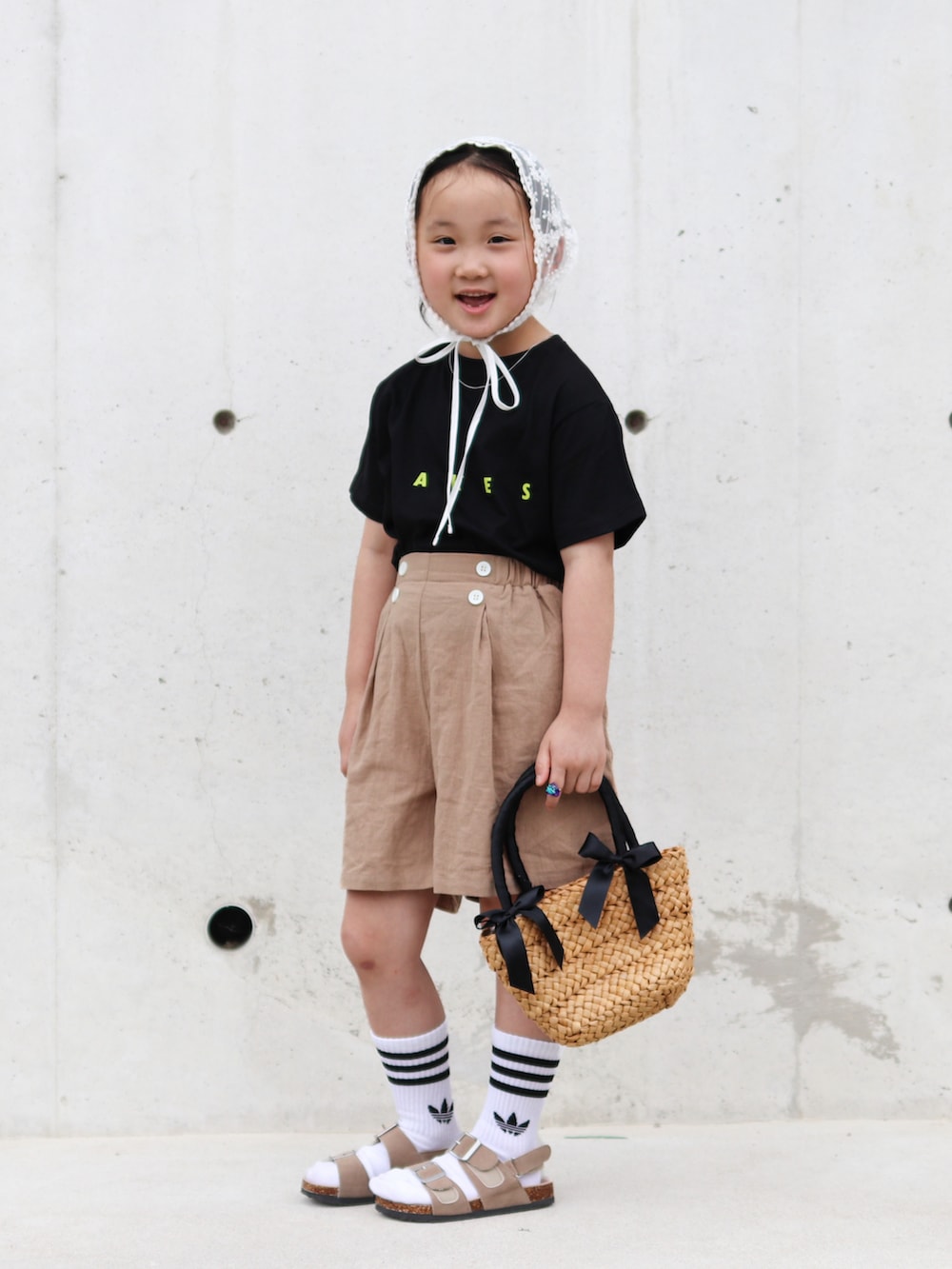 ベージュ系のその他パンツ、ベージュ系のサンダル、ブラック系のTシャツ/カットソーを着用したキッズの夏コーディネートの2枚目の写真