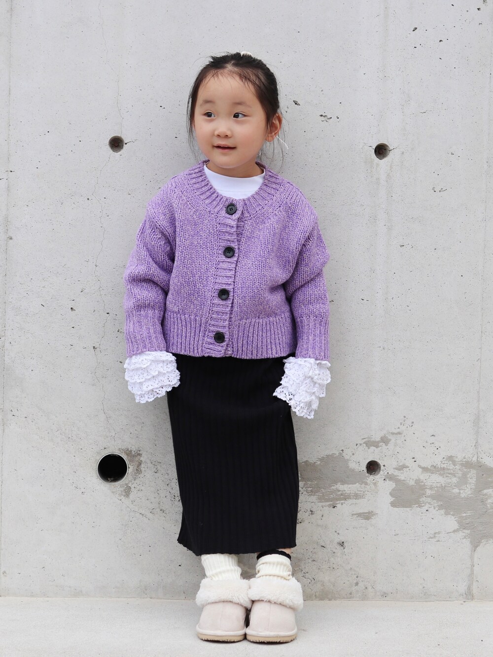 パープル系のカーディガン/ボレロ、ホワイト系のTシャツ/カットソー、ブラック系のスカートを着用したキッズの秋コーディネートの4枚目の写真