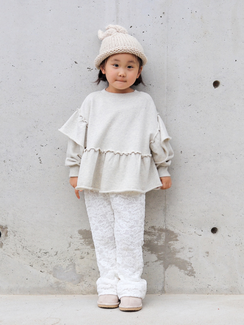 グレー系のスウェット、ホワイト系のその他パンツ、ベージュ系のブーツを着用したキッズの秋コーディネートの2枚目の写真