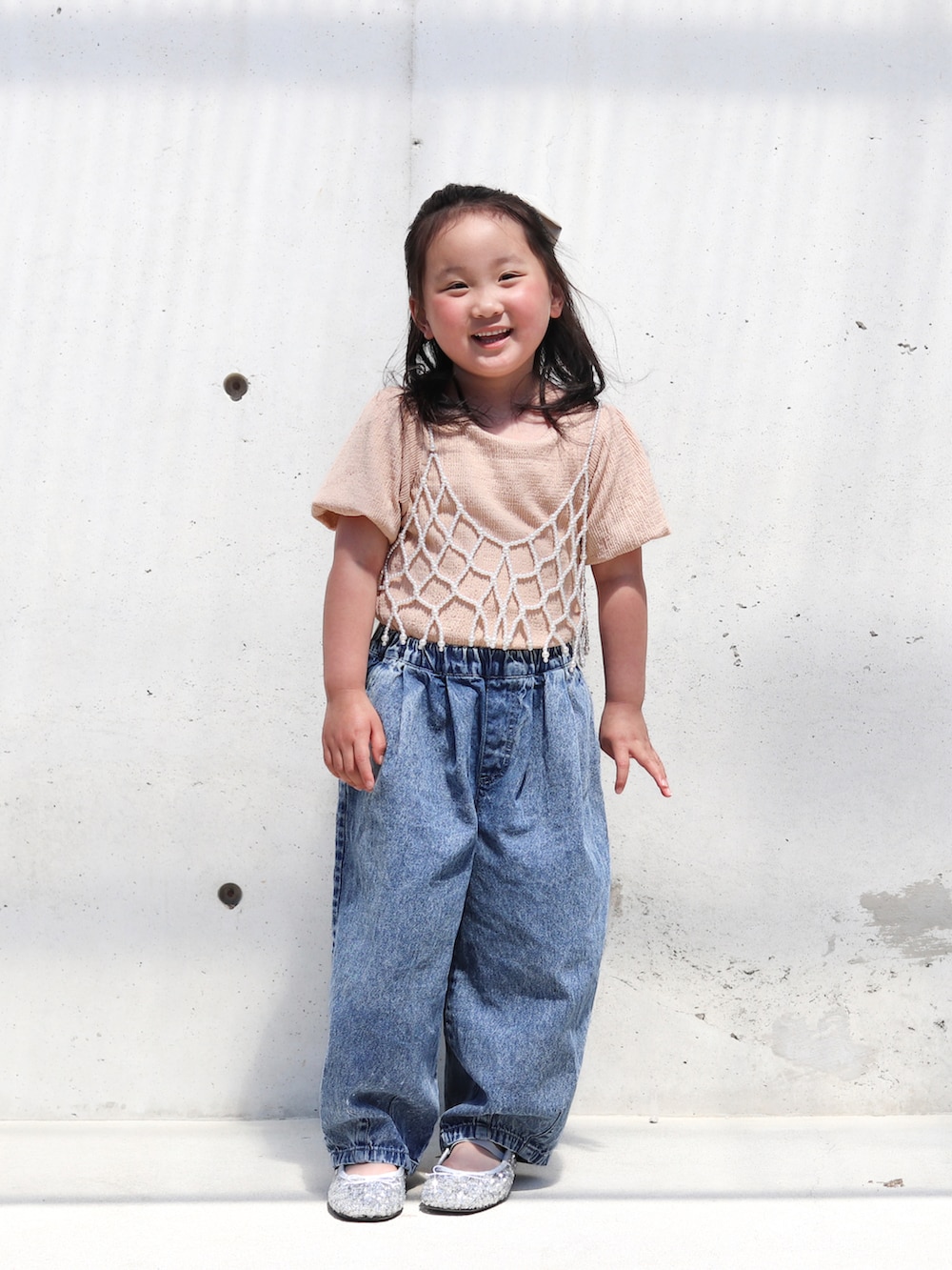 ピンク系のTシャツ/カットソー、ブルー系のデニムパンツ、シルバー系のバレエシューズを着用したキッズの春コーディネートの2枚目の写真