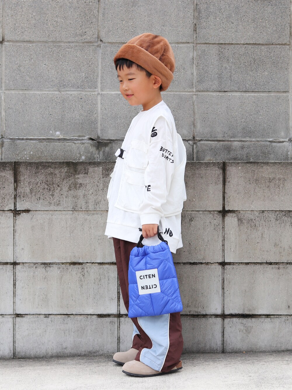 ホワイト系のTシャツ/カットソー、ホワイト系のベスト、ブラウン系のその他パンツを着用したキッズの秋コーディネートの2枚目の写真