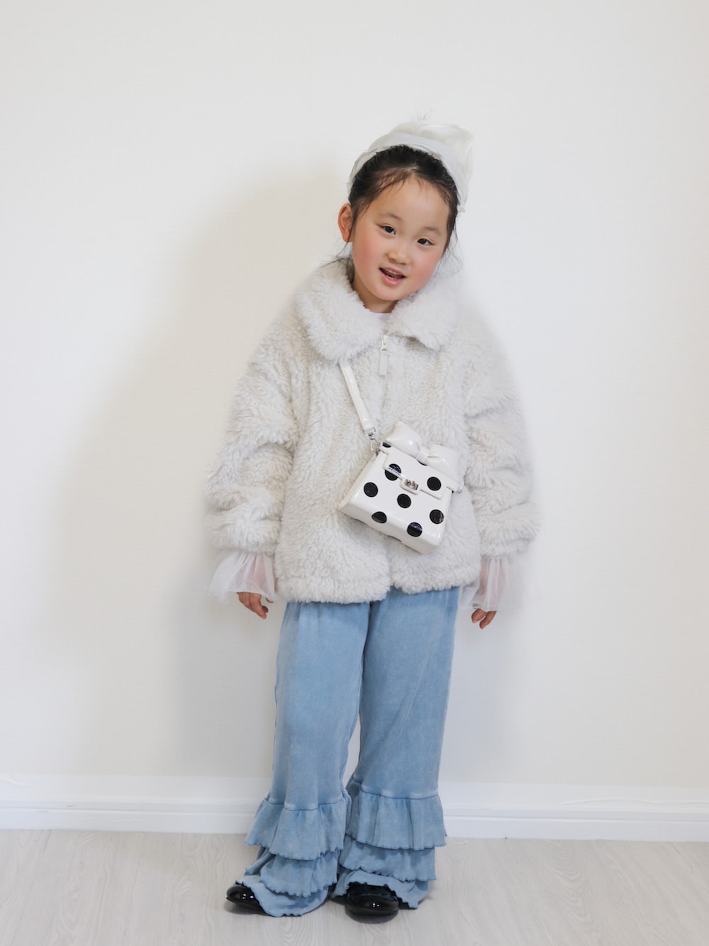 ホワイト系のTシャツ/カットソー、ブルー系のその他パンツ、ホワイト系のショルダーバッグを着用したキッズの冬コーディネートの2枚目の写真