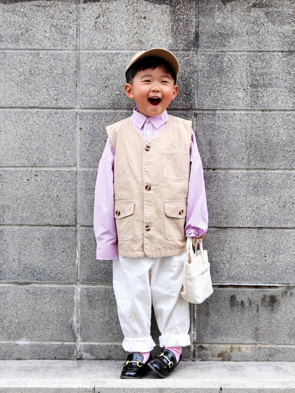 ピンク系のシャツ/ブラウス、ベージュ系のベスト、ホワイト系のその他パンツを着用したキッズの春コーディネートの2枚目の写真