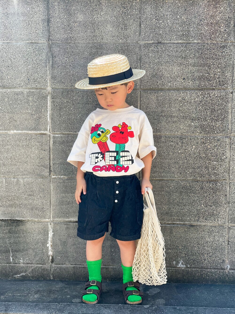 ホワイト系のTシャツ/カットソー、ブルー系のデニムパンツ、ブラウン系のサンダルを着用したキッズの夏コーディネートの2枚目の写真