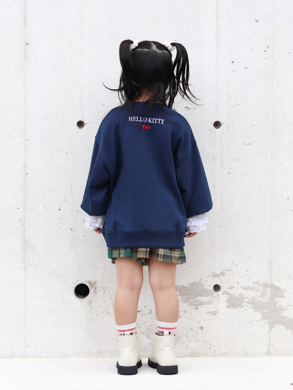 ホワイト系のTシャツ/カットソー、ホワイト系のブーツ、グリーン系のスカートを着用したキッズの秋コーディネートの3枚目の写真
