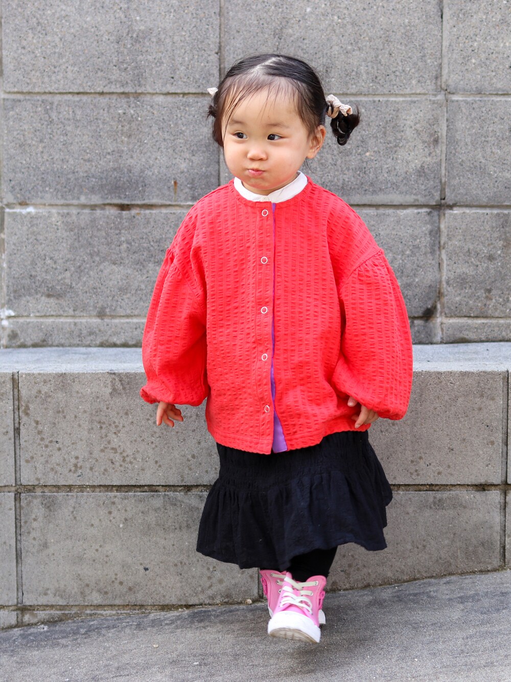 レッド系のカーディガン/ボレロ、ホワイト系のシャツ/ブラウス、ブラック系のスカートを着用したキッズの冬コーディネートの5枚目の写真