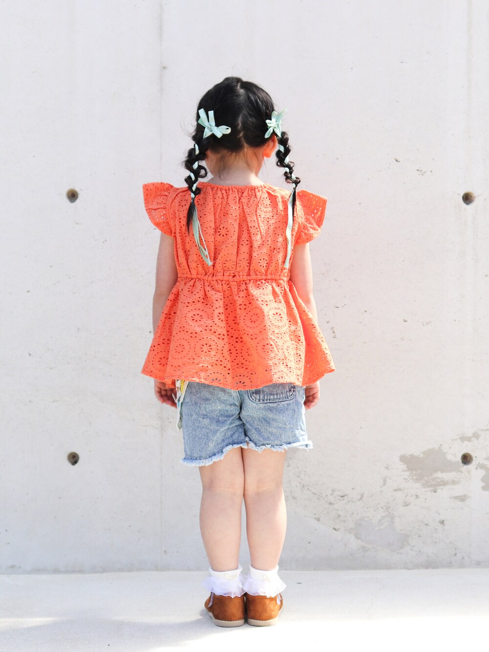 オレンジ系のシャツ/ブラウス、ブルー系のその他パンツ、イエロー系のサンダルを着用したキッズの春コーディネートの3枚目の写真