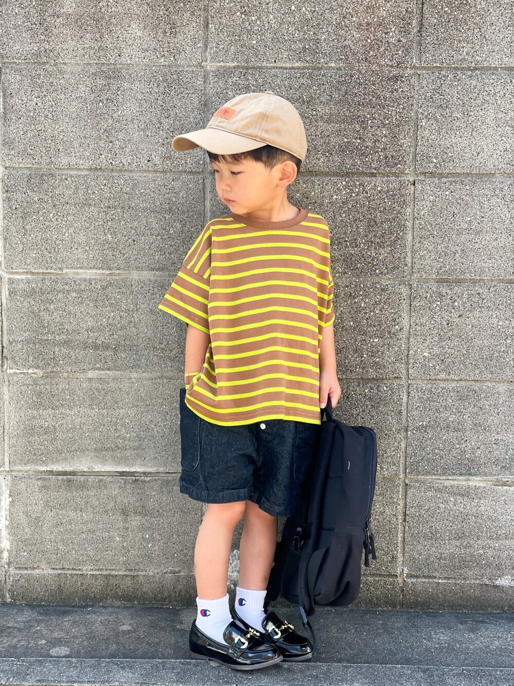 ブラウン系のTシャツ/カットソー、ブルー系のデニムパンツ、ブラック系のローファーを着用したキッズの夏コーディネートの3枚目の写真