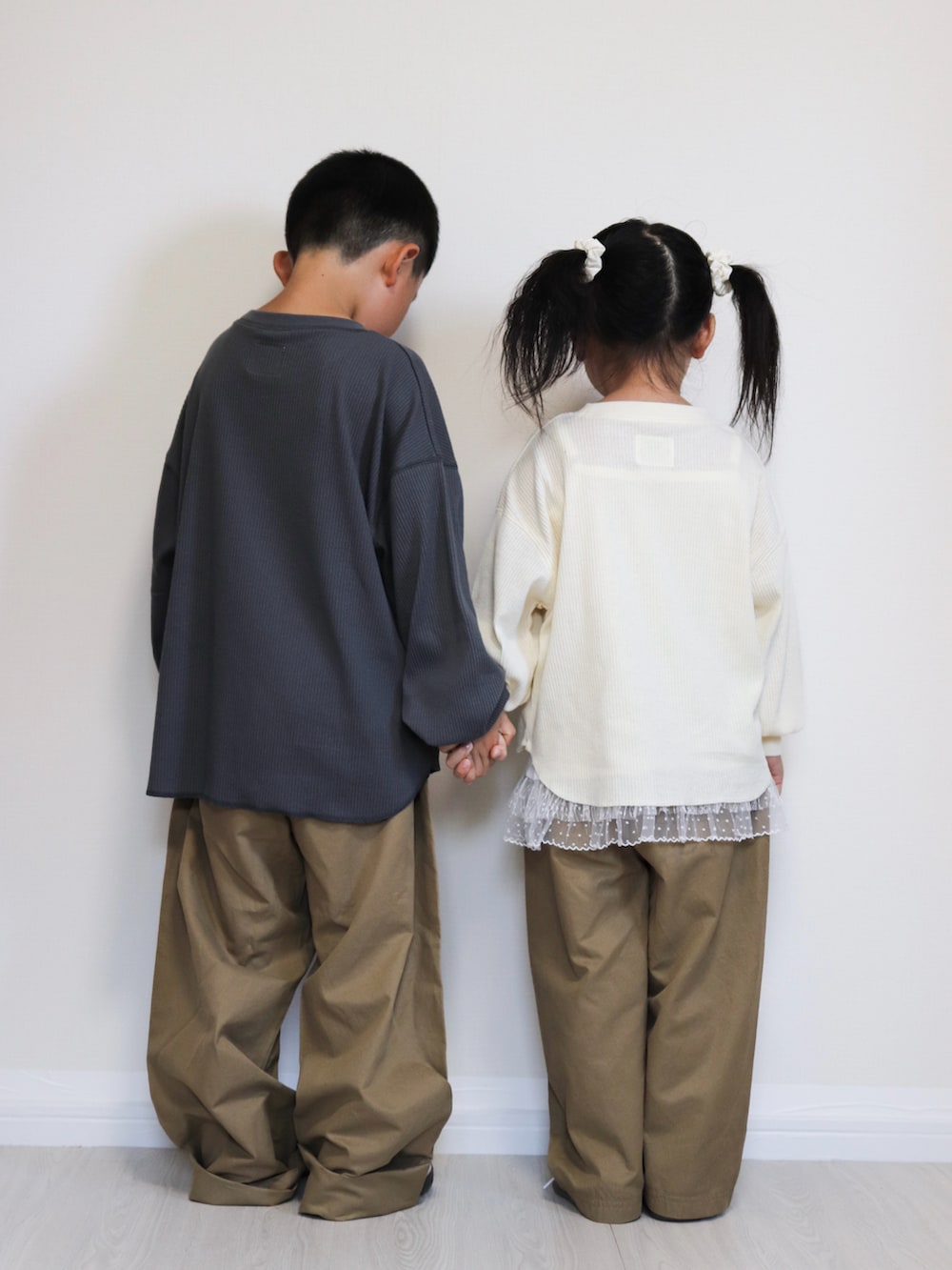 ホワイト系のスニーカー、ホワイト系のスニーカー、グレー系のTシャツ/カットソーを着用したキッズの秋コーディネートの3枚目の写真