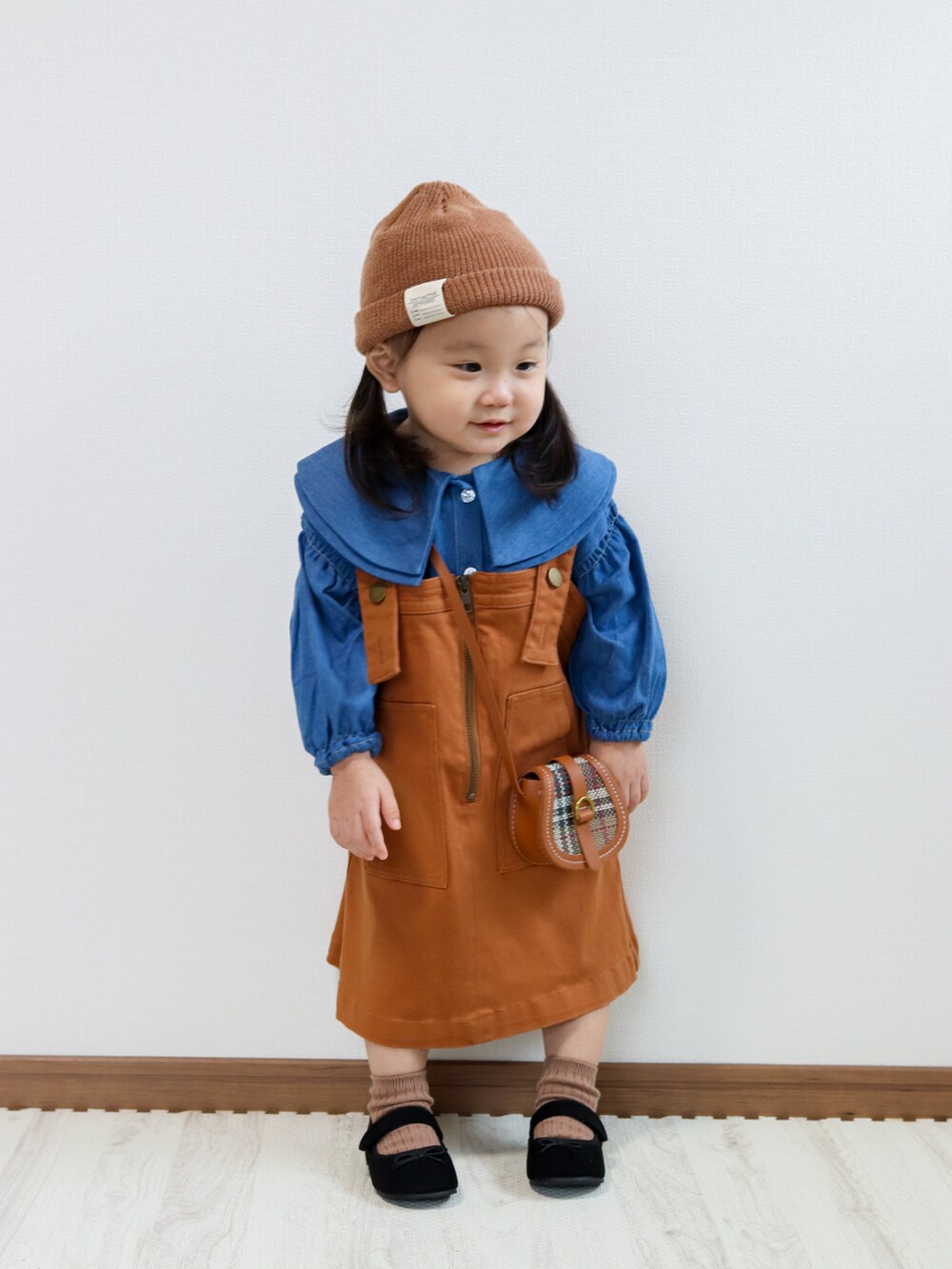 ブルー系のシャツ/ブラウス、イエロー系のジャンパースカート、ブラック系のその他シューズを着用したキッズの秋コーディネートの2枚目の写真