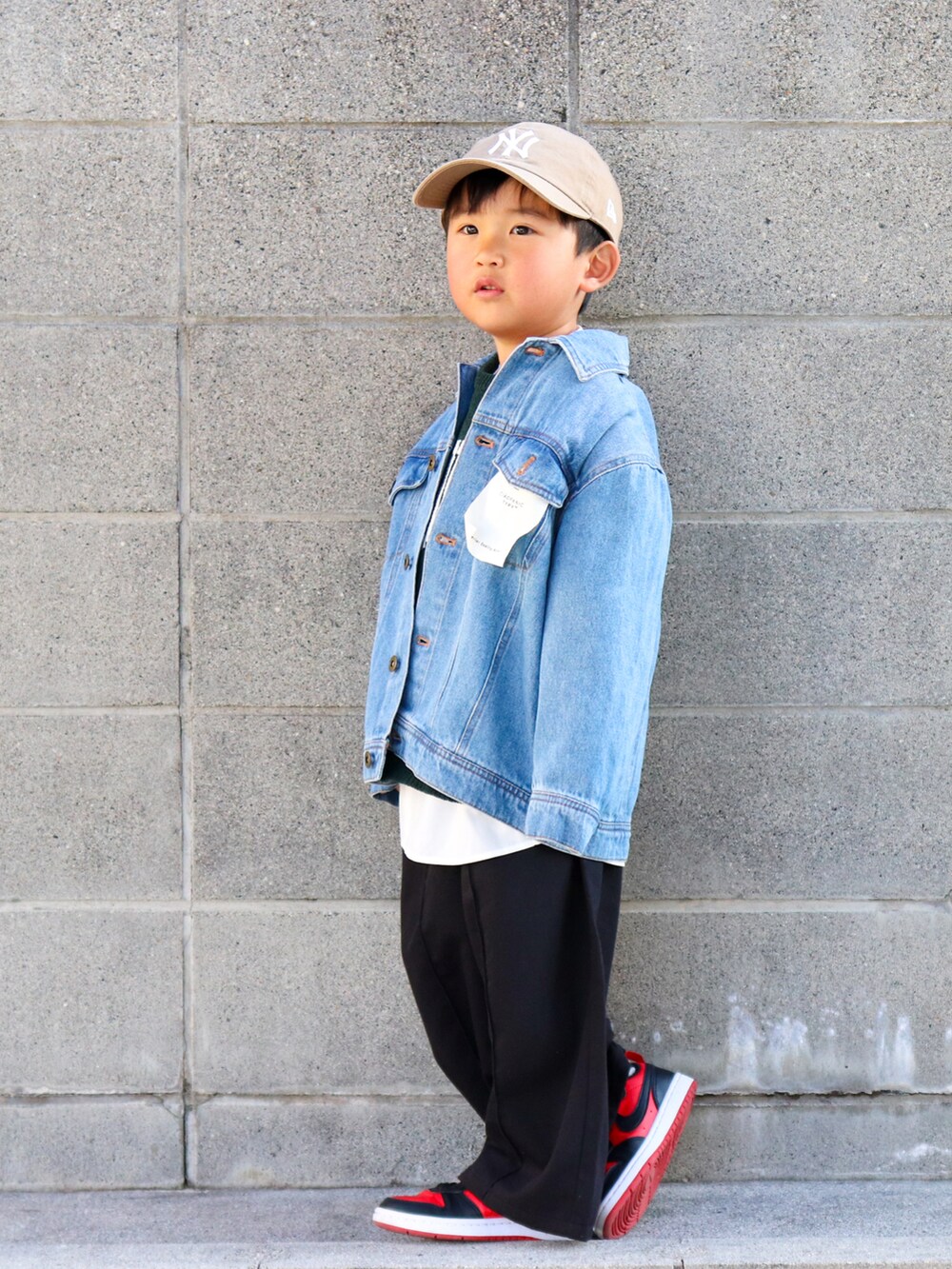 ブルー系のデニムジャケット、グリーン系のニット/セーター、ホワイト系のシャツ/ブラウスを着用したキッズの冬コーディネートの2枚目の写真