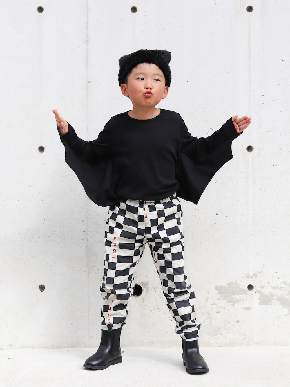 ブラック系のTシャツ/カットソー、ブラック系のブーツ、その他のその他パンツを着用したキッズの秋コーディネートの2枚目の写真