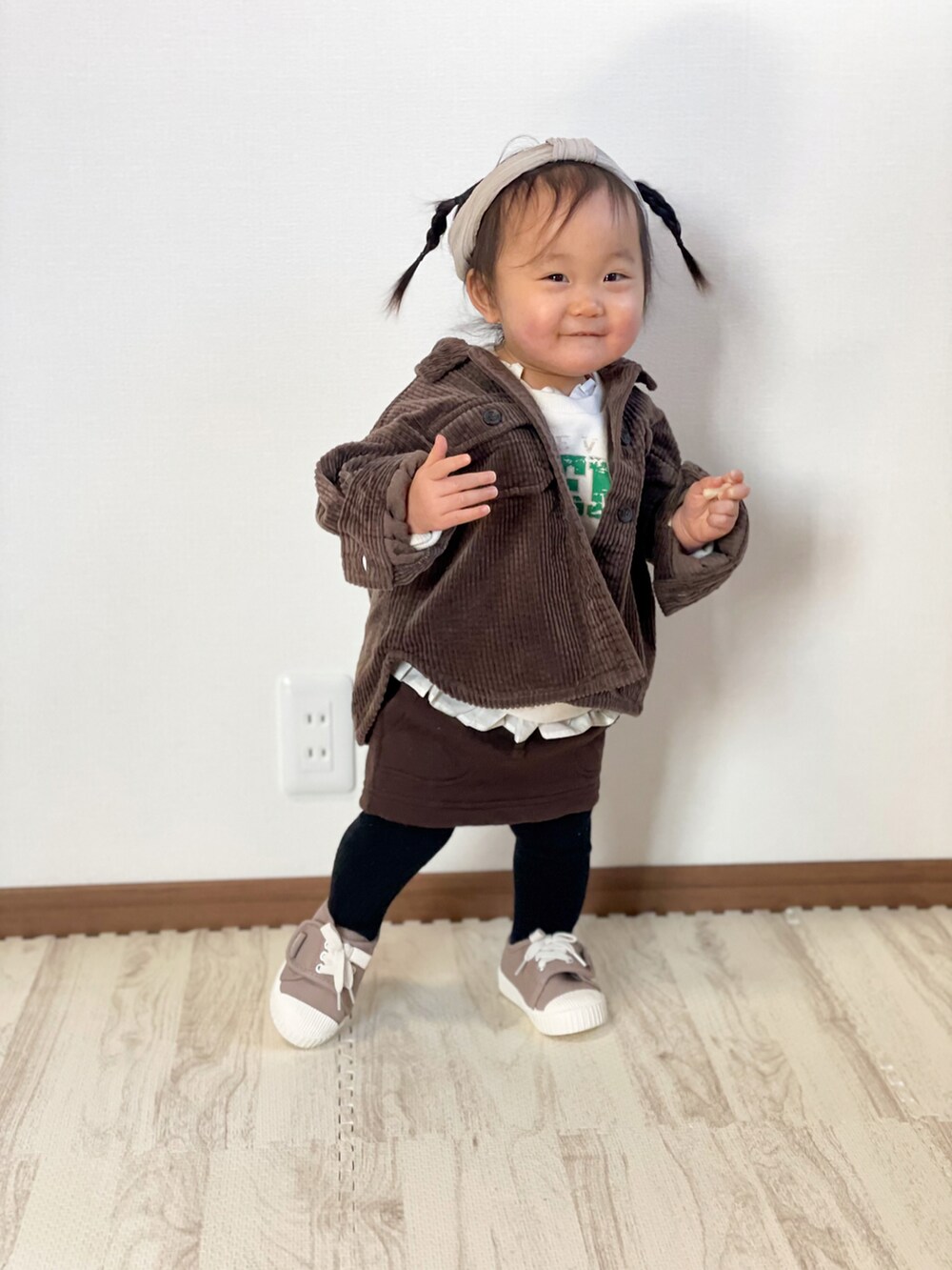 ブラウン系のシャツ/ブラウス、ホワイト系のスウェット、ブラウン系のスカートを着用したキッズの冬コーディネートの3枚目の写真
