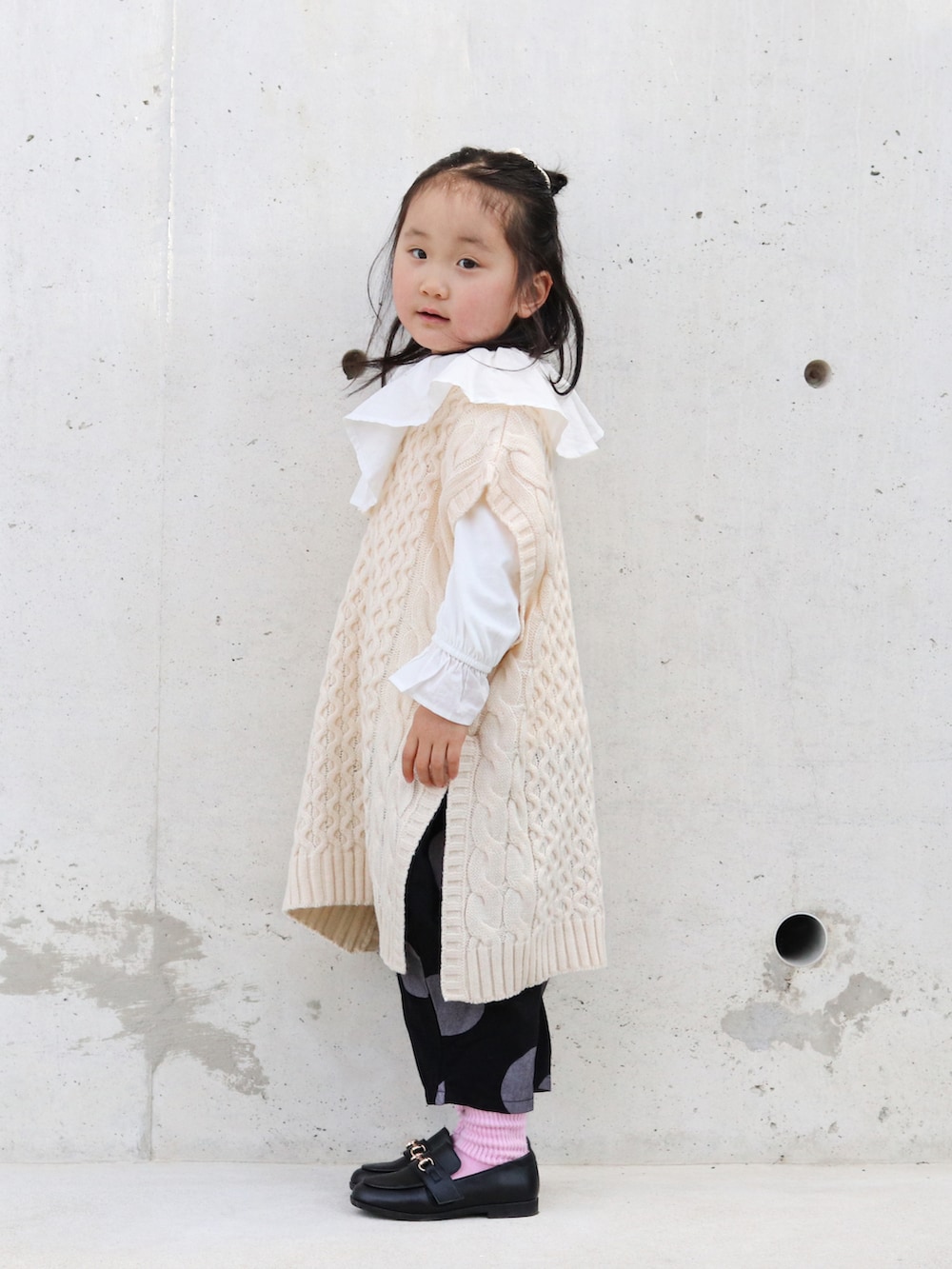 ホワイト系のTシャツ/カットソー、ベージュ系のベスト、ブラック系のその他パンツを着用したキッズの冬コーディネートの3枚目の写真