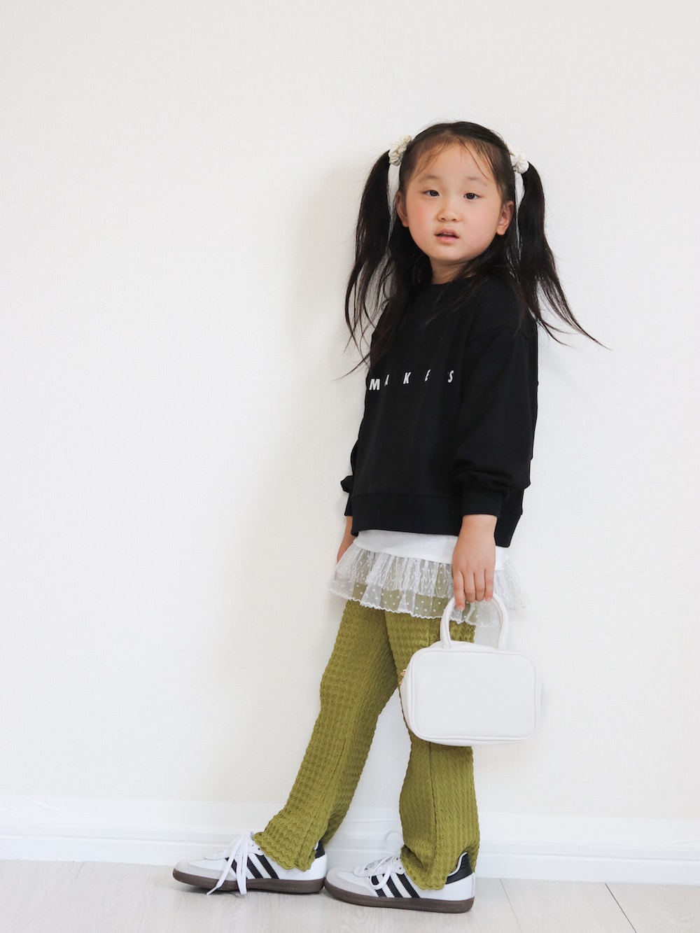 ホワイト系のショルダーバッグ、ホワイト系のスニーカー、ブラック系のTシャツ/カットソーを着用したキッズの秋コーディネートの3枚目の写真