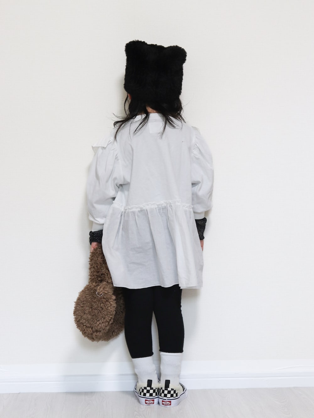 ホワイト系のワンピース、ブラック系のスニーカー、ブラック系のTシャツ/カットソーを着用したキッズの秋コーディネートの3枚目の写真