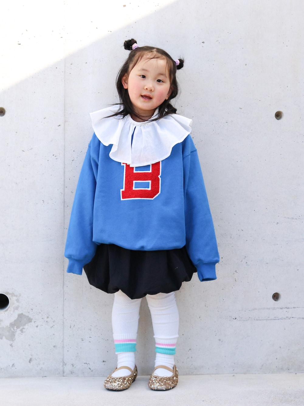 ブルー系のスウェット、ホワイト系のTシャツ/カットソー、ブラック系のスカートを着用したキッズの冬コーディネートの3枚目の写真